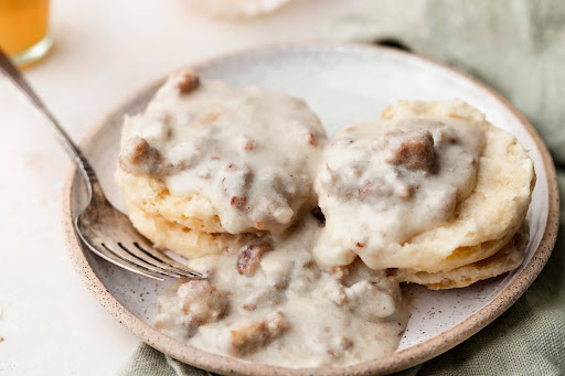 Homemade biscuits and rich gravy served on a plate, illustrating a delicious biscuits and gravy recipe