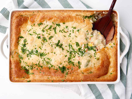 Freshly baked chicken cobbler in a baking dish, showcasing golden-brown crust and savory filling.