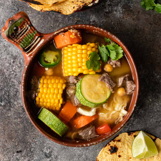 Delicious Caldo de Res in a bowl, garnished with fresh herbs and vegetables, perfect traditional Mexican beef soup recipe.