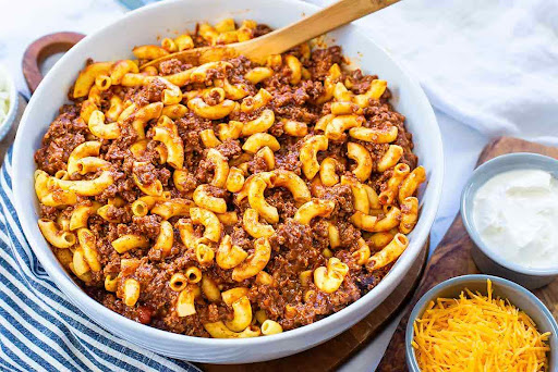 Homemade chili mac recipe in a bowl, featuring a hearty blend of macaroni, ground beef, beans, and spices.